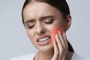 A woman with a pain in her mouth.